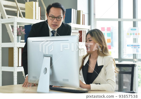Asian business man and woman looking at computer laptop screen to discuss and working in office Asian business man and woman looking at computer laptop screen to discuss and working in office 93857538