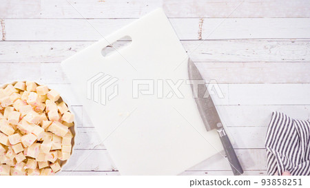 Flat lay. Step by step. Cutting homemade candy cane fudge on a white cutting board. Flat lay. Step by step. Cutting homemade candy cane fudge on a white cutting board. 93858251