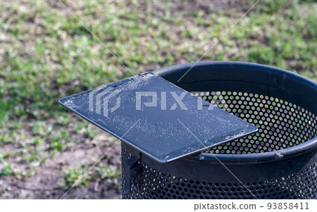 Modern tablet with highly broken screen lies on the trash. 93858411