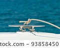 Detail image of yacht rope cleat on sailboat deck. 93858450