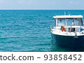 Small boat on blue water of ocean. 93858452
