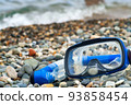 Blue snorkel and mask for diving on the pebble beach. 93858454
