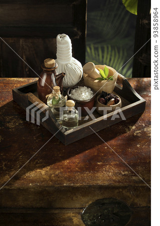 close up view of mortar, salt, oil and Herbal Compress on color back. 93858964