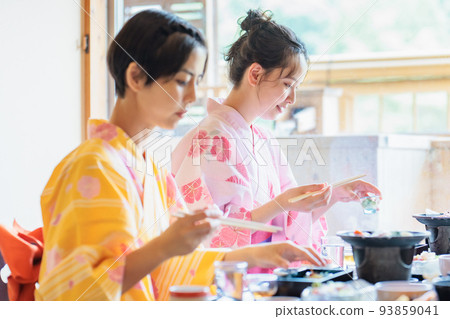 A young woman eating in a yukata at a hot spring inn, a girls' trip 93859041