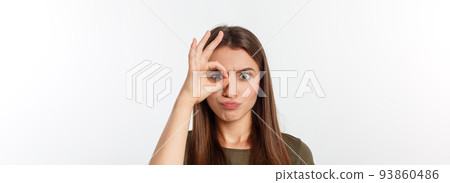Close up portrait of cheerful, cute, stylish,attractive, trendy girl making binoculars with fingers, isolated on grey background, having good mood Close up portrait of cheerful, cute, stylish,attractive, trendy girl making binoculars with fingers, isolated on grey background, having good mood 93860486