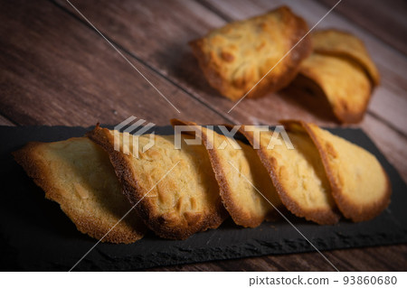 French delicacy pastry tuile with almond on wood background French delicacy pastry tuile with almond on wood background 93860680