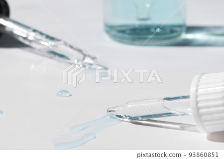 Pipette with fluid serum, oil, face gel cleaner. Cosmetics and healthcare concept closeup. Dose of retinol with air bubbles. Flat lay. Monkeypox, coronavirus research 93860851