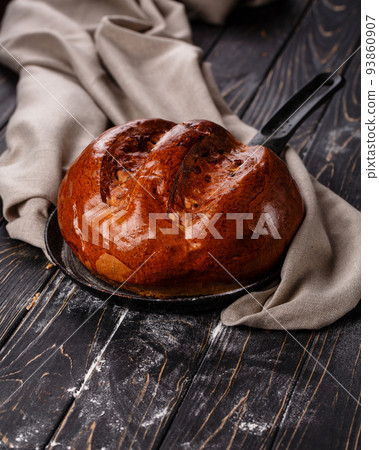 Close up of fragrant baked homemade bread on dark wooden table. 93860907