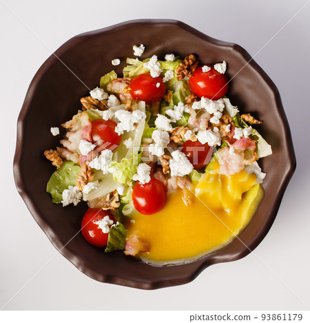 Salad with bacon, feta french fries with sausages in cheese sauce. 93861179