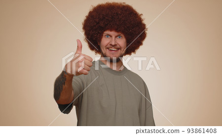 Bearded man raises thumbs up agrees or gives positive reply recommends advertisement likes good 93861408