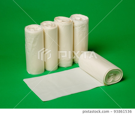 Five rolls of biodegradable eco plastic white garbage bags on green background. 93861536