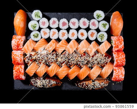 Maki ands rolls with tuna, salmon, shrimp, crab and avocado are served on stone slate. Maki ands rolls with tuna, salmon, shrimp, crab and avocado are served on stone slate. 93861559