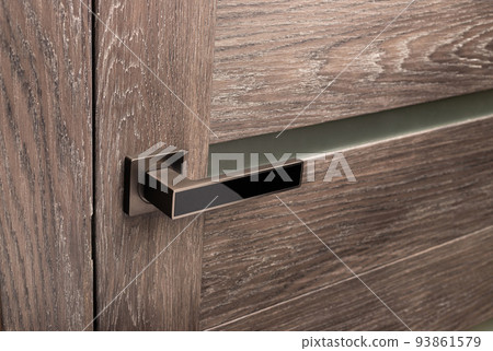 Brown wooden interior door with emphasis on metal handle. 93861579