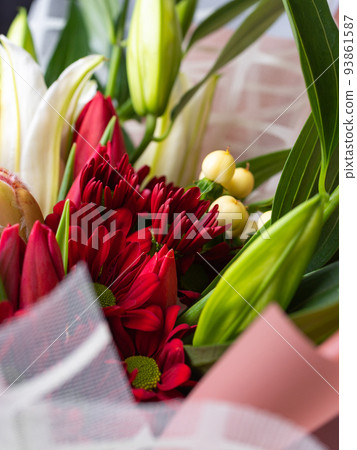 Close up of red chrysanthemums in a festive bouquet among white lilies. 93861587