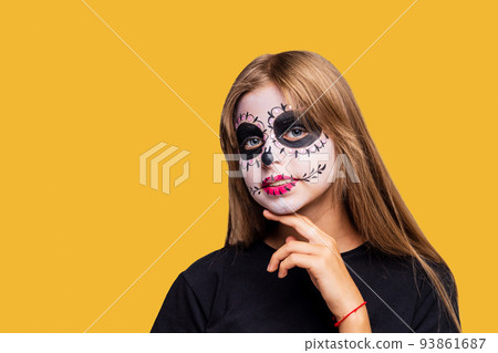 teenager girl with cool skull makeup with roses on head looking at camera in yellow studio teenager girl with cool skull makeup with roses on head looking at camera in yellow studio 93861687
