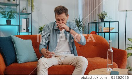 Sad depressed young man suffers from unrequited love, drinking vodka, problem, bad news, bankruptcy Sad depressed young man suffers from unrequited love, drinking vodka, problem, bad news, bankruptcy 93862026