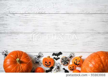 Halloween background, top view. Pumpkins and sweets on white wooden table, flat lay. 93863008