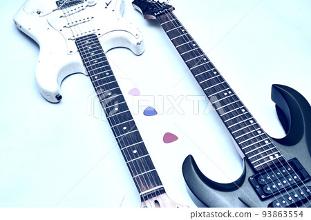 Two guitar, neck fretboard mediators plectrum on a pale blue.Black, white 93863554