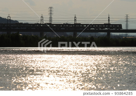 Keio Series 8000 train crossing the Tama River illuminated by the setting sun_Photographed on August 9, 2022 Keio Series 8000 train crossing the Tama River illuminated by the setting sun_Photographed on August 9, 2022 93864285