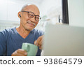 Smiling Asian Senior man using laptop 93864579