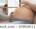 Woman playing belly with fingers 93864611