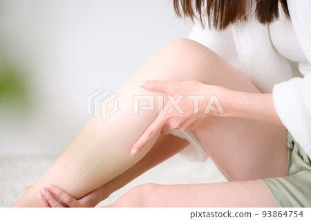 A woman who massages her feet and takes care of her hair, no face, close-up A woman who massages her feet and takes care of her hair, no face, close-up 93864754