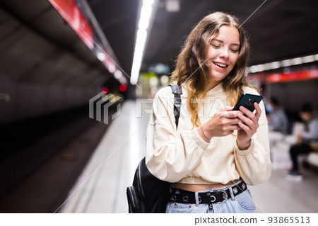 Young european female with mobile waiting the metro 93865513