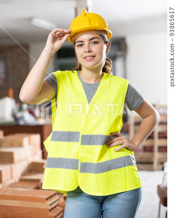 Woman builder posing on indoor construction site Woman builder posing on indoor construction site 93865617