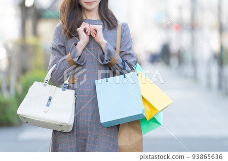 一個女人抱著許多購物袋 一個女人抱著許多購物袋 93865636