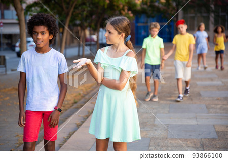 Boy and girl walking during summer day and having conversation 93866100