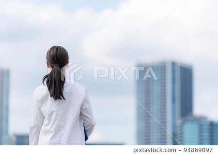 一個穿著白大褂的女人看著這座城市 93869097