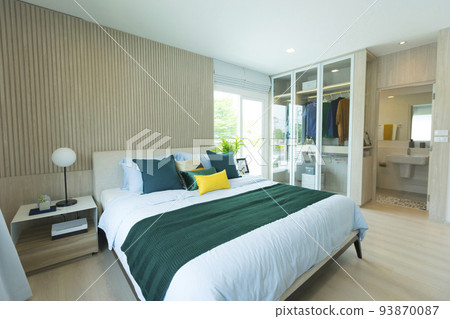 Modern bedroom interior design in green tones, natural textures with wooden bedframe 93870087