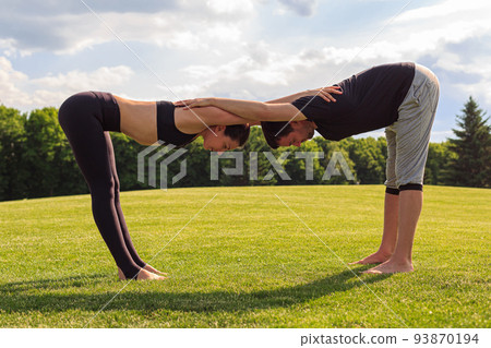 Young healthy couple doing acrobatic yoga exercise in park Young healthy couple doing acrobatic yoga exercise in park 93870194