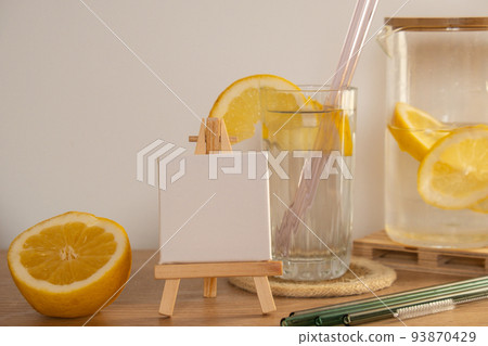 Empty painting canvas for you text Mock up Copy space Glass of water with fresh lemon juice with Reusable glass Straws Detox cold tonic water with sunny lemon slices Low-waste lifestyle Eco-Friendly 93870429