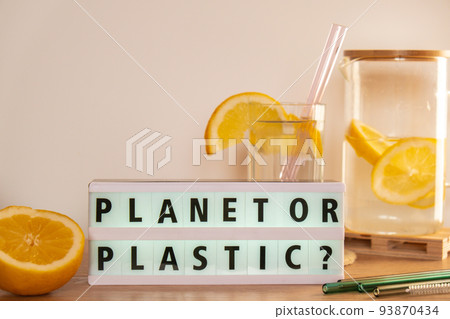 Lightbox with text PLASTIC OR PLANET Glass of water with fresh lemon juice with Reusable glass Straws Detox cold tonic water with sunny lemon slices Low-waste lifestyle Eco-Friendly Drinking Straw  93870434