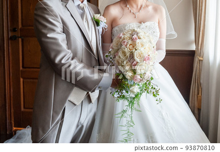 Bride and groom holding a bouquet Wedding image 93870810