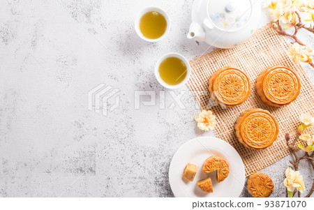 Chinese Mid-Autumn Festival concept made from mooncakes, tea and plum blossom on white stone background. Chinese Mid-Autumn Festival concept made from mooncakes, tea and plum blossom on white stone background. 93871070
