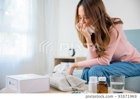 Asian young girl cold sick she sneeze with tissue paper on sofa 93871969