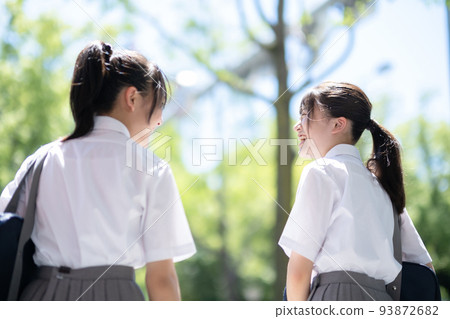 Back view of students having a conversation 93872682