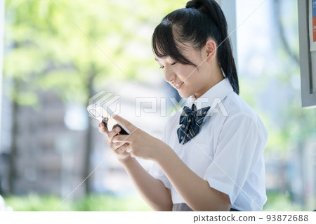 A student watching a smartphone 93872688