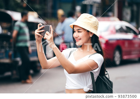 Young asian woman with smart phone. Khaosan road background. 93873500