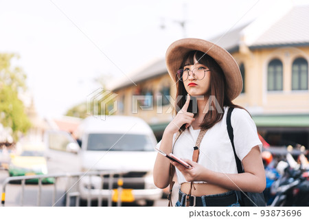 Asian glasses girl traveller thinking about plan trip in Bangkok, Thailand. 93873696
