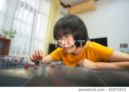 Happy young adult asian woman playing board game on top table at home eye looking camera. 93873953