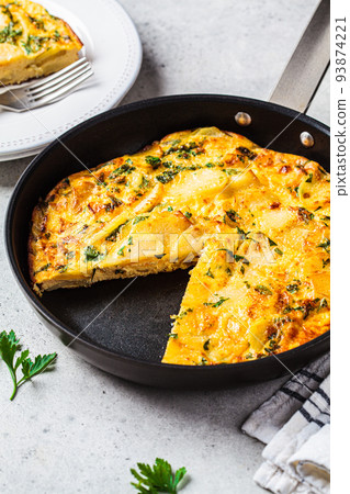 Traditional Spanish potato tortilla or omelette in black pan. 93874221