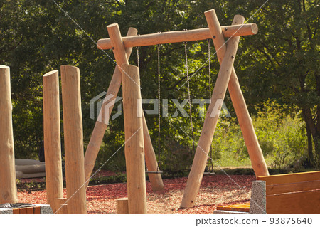 children's swing on wooden poles on the playground 93875640