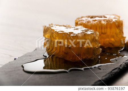 Honeycomb on slate tray on kitchen table macro view 93876197