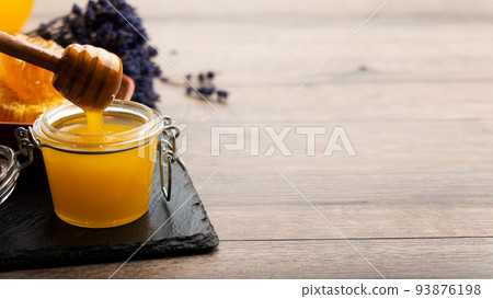 Honey on wooden honey-dipper closeup food background with copy-space 93876198
