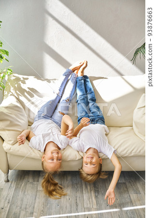 Pretty little girl and boy are lying on sofa in living room 93876663