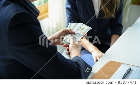 A businessman tries to give money or bribe to a female worker or lawyer. Corruption A businessman tries to give money or bribe to a female worker or lawyer. Corruption 93877471