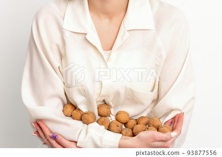 The caucasian woman holds a bunch of walnuts in her hands isolated on a white background 93877556